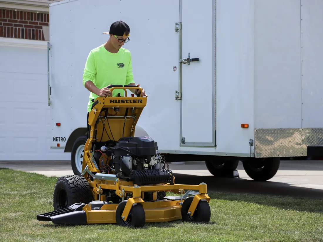 Landon's Lawn Care mower and equipment trailer at a commercial property