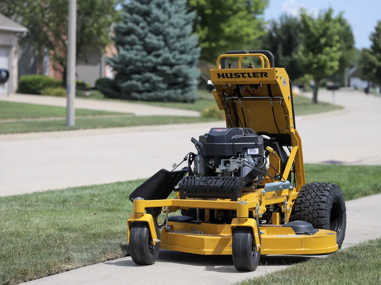 Landon's Lawn Care mower on a clean concrete driveway at a residential property